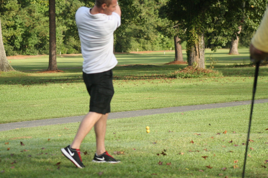 Corey drives the ball down the fairway.