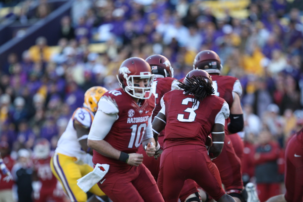 Arkansas QB Butler hands the ball off.