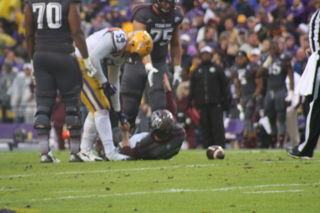 LSU lb Rasco helps up QB Johnny Manziel after a play.