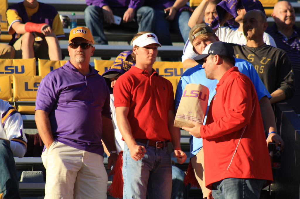 A Ole Miss Fan holding a LSU bag of popcorn....  
